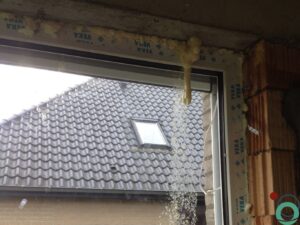 Raamprofiel en glas besmeurd met uitgeharde PU-schuim, klaar voor reiniging met Chemifor producten