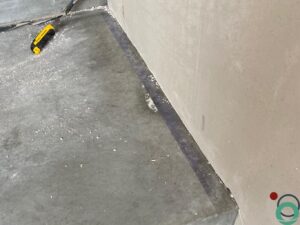 Betonnen vloer met een zichtbare beschadigde streep na het verwijderen van tape