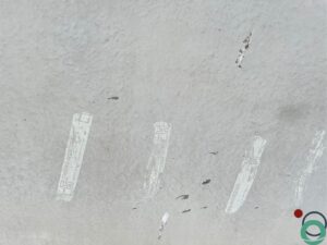 Betonwand met enkele strepen stickerlijm die verwijderd moeten worden
