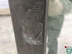Zwarte lijmstructuur zichtbaar op aluminium raamprofiel na het verwijderen van een label