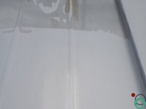 Oppervlak dat gedeeltelijk gereinigd is van olie en vet met Chemifor Olie en Vetverwijderaar, duidelijke scheiding zichtbaar