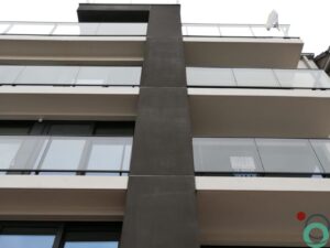 Gevel van appartementsgebouw met contrasterende witte en donkere betonelementen