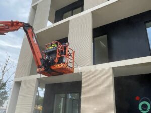 reiniging gevel van een modern gebouw met verticale structuur vanuit een hoogwerker