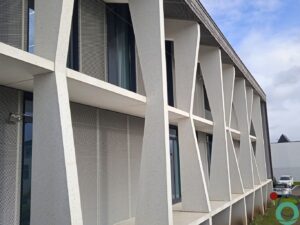 Strakke moderne gevel met wit architectonisch beton en speelse schuine kolommen