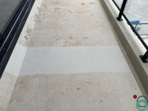 Verwijderen van roestvlekken op betonnen terras met duidelijk zichtbaar reinigingsresultaat