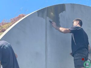 Manueel verwijderen van mos op betonwand
