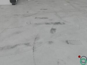 Lichte betonnen parkeerzone met opvallende zwarte rubbersporen van autobanden