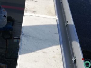 Wit balkon met verticale bruine uitlopers veroorzaakt door vervuiling of roestvorming