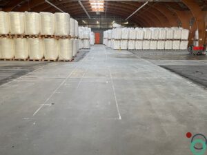 Dieptereiniging van vervuilde vloer in een industriepand met zichtbare sporen en resten