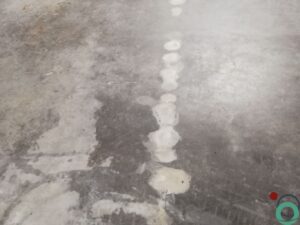 Kalkvlekken zichtbaar op een betonnen vloer in een industriële omgeving
