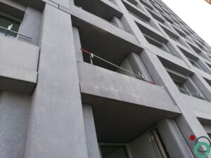Cementresten zichtbaar op een verticale betonwand na het ontkisten of metselen