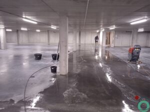 Dieptereiniging van een betonnen parkeergaragevloer met professionele apparatuur