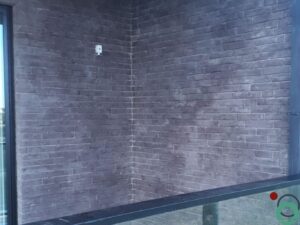 Witte zoutuitbloeiing zichtbaar op een donkere natuursteen of gevelsteen