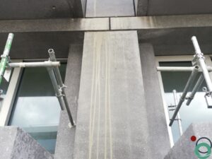 Cementresten zichtbaar op een verticale betonwand na het ontkisten of metselen