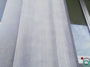 Cementresten zichtbaar op een verticale betonwand na het ontkisten of metselen