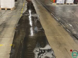 Dieptereiniging van vervuilde vloer in een industriepand met zichtbare sporen en resten