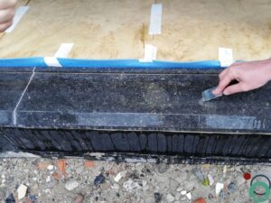 Witte kalksporen zichtbaar op zwarte raamprofielen na blootstelling aan water en vervuiling