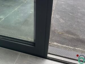 Witte kalksporen zichtbaar op zwarte raamprofielen na blootstelling aan water en vervuiling