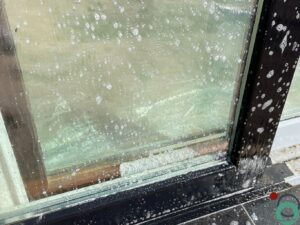 Olievervuiling wordt verwijderd van glas en blauwe steen met een gerichte reiniging