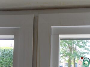 Resten van uitgeharde PU-schuim zichtbaar op een wit kunststof raamkader