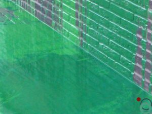 Groene verfspetters en druipers op een bakstenen muur en bestrating