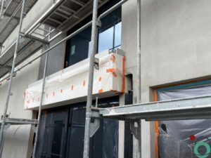 Wit balkon met verticale bruine uitlopers veroorzaakt door vervuiling of roestvorming