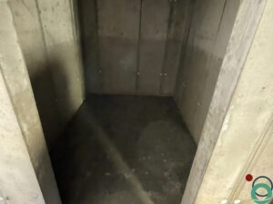 Groenaanslag zichtbaar op een betonnen muur en in behandeling voor verwijdering