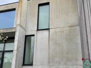 Vervuilde betongevel met zichtbare aanslag, klaar voor reiniging en bescherming