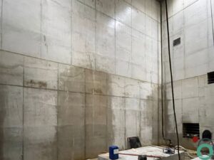 Roeststrepen lopen uit over verticale zichtbetonnen wanden in een betonnen constructie