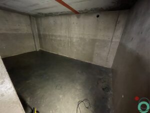 Groenaanslag zichtbaar op een betonnen muur en in behandeling voor verwijdering