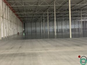 Industriële reiniging in uitvoering op een vervuilde vloer binnen een productieomgeving