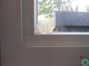 Resten van uitgeharde PU-schuim zichtbaar op een wit kunststof raamkader