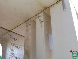 Wit balkon met verticale bruine uitlopers veroorzaakt door vervuiling of roestvorming